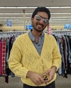 dhruv stands in a yellow sweater